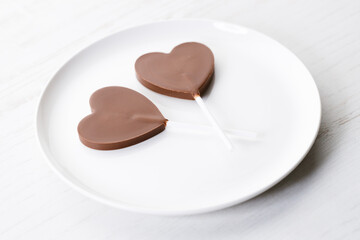 Chocolate hearts on white wooden background, valentines day.