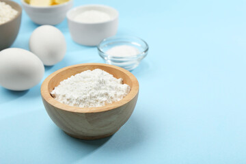 Wall Mural - Baking powder and other ingredients for making dough on light blue background, space for text