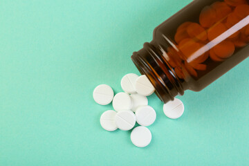 Wall Mural - Bottle of antibiotic pills on turquoise background, top view. Space for text