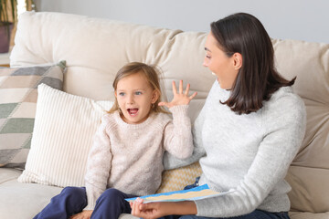 Canvas Print - Cute little girl showing her drawing to beautiful mother at home