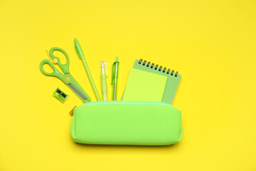 Wall Mural - Pencil case and different stationery on yellow background, flat lay