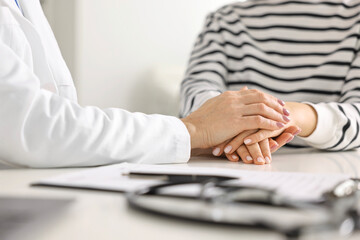 Wall Mural - Doctor supporting patient during appointment in hospital, closeup of hands