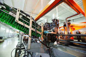 Poster - bottling line in a factory showcasing machinery and green bottles in production