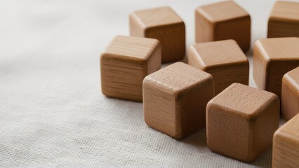Poster - Wooden blocks arranged in a soft focus along the right side of a textured fabric surface with natural hues emphasizing simplicity and creativity.