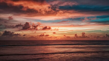Poster - Tranquil ocean horizon at sunset with vibrant orange and blue hues reflecting on calm water and dramatic cloud formations above