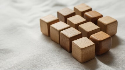 Leinwandbilder - Minimalist wooden cubes arranged in two rows on a light textured fabric background showcasing natural wood tones and subtle shadows.