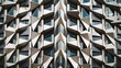 © Gular - Geometric facade of contemporary building showcasing white triangular shapes arranged at dynamic angles against a glass window backdrop.