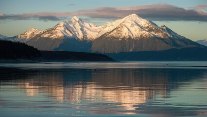 Aufkleber - Snow-capped mountains reflect in calm water under soft winter sunlight in the Pacific Northwest, with blue and white tones creating a serene landscape.