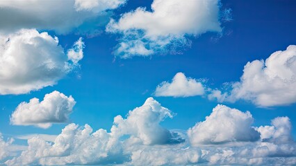Poster - Serene sky with fluffy white clouds scattered across a vibrant blue background, creating a peaceful and tranquil natural atmosphere.