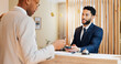 © peopleimages.com - Hotel, credit card and man at desk with customer, pos and friendly reception service for hospitality. Check in, payment and receptionist with client at counter for accommodation, booking and travel