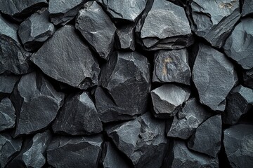 Poster - Close up view of a pile of black slate rocks arranged in a natural setting on a sunny day