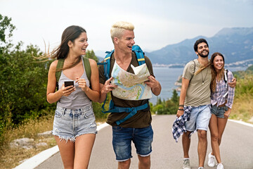Wall Mural - friendship, travel, vacation, summer and people concept. group of smiling friends with map traveling