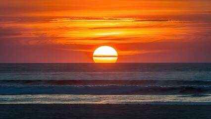 Poster - Sunset over tranquil beach with vibrant orange hues reflecting on the calm ocean waves under a clear sky, creating a serene atmosphere