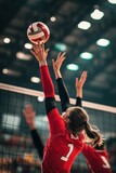 Volleyball match in indoor arena with players reaching for ball, teamwork, competition and athletic performance captured during sports event. Excitement and energy.