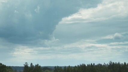Wall Mural - Time Lapse Dramatic Sky With Heavy Rain Clouds Above Forest. Time-lapse Colorful Cloudy Dark Blue Sky Fluffy Clouds. Rain Above Forest Landscape. Rain Cloud Formation Timelapse. Dark Sky. Bad Weather
