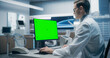 © Gorodenkoff - Male Scientist in a White Lab Coat Works on a Green Screen Computer in a Modern Medical Lab, Focusing on Research and Healthcare Analysis in a High-tech Hospital Environment