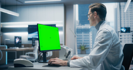 Aufkleber - A Male Scientist in a White Lab Coat Works on a Green Screen Computer in a Advanced Medical Lab, Focusing on Advanced Healthcare Research and Analysis in a High-tech Hospital Environment