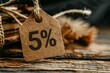 © juliars - Close up of a cardboard price tag showing a 5 percent discount, suggesting a promotional offer or sale
