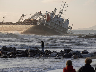 the ship stranded and wrecked. stormy sea in overcast weather waves crash on a pier near the shore i