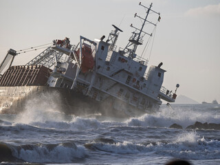 the ship stranded and wrecked. stormy sea in overcast weather waves crash on a pier near the shore i