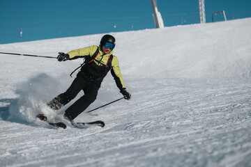 Wall Mural - A skilled skier performing dynamic turns on a snowy slope under clear blue sky. The scene captures the excitement and energy of skiing in a picturesque winter landscape.