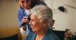 © peopleimages.com - Nurse, brush and senior woman with hairstyle for self care, grooming or morning routine at assisted living. Healthcare, retirement home and caregiver help elderly female patient with beauty treatment