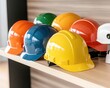 © POOM - Colorful Safety Helmets Displayed on a Wooden Shelf in Office