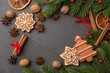 © Yuwadee - A Festive Arrangement of Christmas Cookies, Spices, and Evergreens on a Dark Background