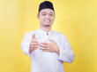 © Iqy - A smiling asian muslim man in white prayer clothes offering handshake as greeting and welcoming.