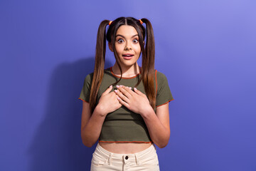 Wall Mural - Excited teenager with expressive face and ponytails standing against violet background