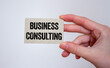 © Emre Akkoyun - Business consulting message written on a card in hand. Conceptual business consulting symbol. Copy space.