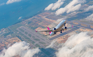 Wall Mural - Airplane taking off from airport - Passenger airplane is flying over amazing mountains and sea - Commercial Tankers and container ships wait in the Straits of Singapore Changi Airport