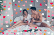 © deagreez - Muscular man propose to merry him giving engagement ring in red box to his amazed lover, couple hold cups of wine, sitting on bedclothes, future husband, wife celebrating valentine day, 14 february
