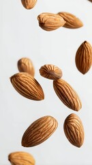 Aufkleber - Many almonds levitating on a white background, creating an interesting visual effect and highlighting the concept of healthy eating and natural snacks
