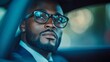 © Mickael - Confident man wearing glasses looking out car window in urban setting with blurred lights in background