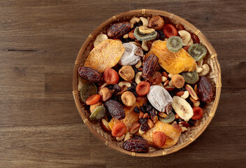 Poster - Mix of dried tropical fruits, nuts, and raisins on a wooden table.