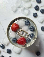 Canvas Print - Fresh strawberries and blueberries chill in a can, surrounded by ice cubes.