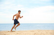 © New Africa - Muscular man running on beach, space for text