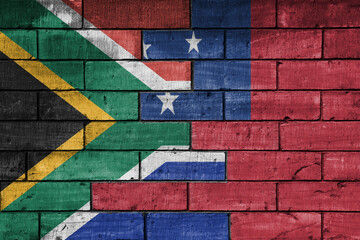 Wall Mural - colourful painted big flag of south africa and flag of Samoa on a massive old brick wall background. concept