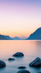 Wall Mural - A serene lake with mountains in the background. The sky is a beautiful mix of orange and pink hues