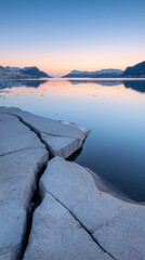 Wall Mural - A rocky shoreline with a body of water in the background. The water is calm and the sky is a beautiful shade of blue