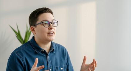 Wall Mural - A man wearing glasses and a blue shirt is talking to someone