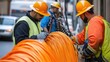 © Djenar - Installation technicians securing optic fiber with cable ties.