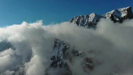 Wall Mural - flying through beautiful white fluffy clouds between high rocky mountains. dolomites alps mountains,
