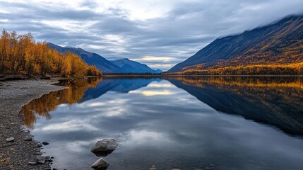 Poster - A panoramic view of a serene lake reflecting autumn trees and a cloudy sky
