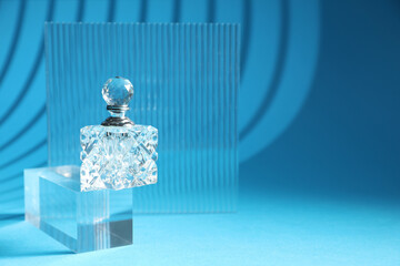 Wall Mural - Stylish presentation of perfume bottle on light blue background, space for text