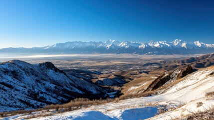 Poster - An expansive view of a mountain range blanketed in snow under a clear blue sky.