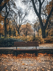 Wall Mural - Autumnal Serenity: A park bench sits amidst a carpet of fallen leaves in a tranquil autumn scene.