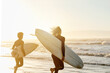 © peopleimages.com - Sunset, enjoying and friends at the beach with surfboards for a hobby, waves and learning an activity. Calm, training and men in the water by the ocean for surfing, competition and sports in the sea