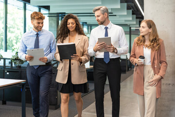 Poster - Group of a professional business team walking and discussing in corridor of modern bright office.